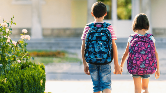 Dos infants van a l'escola el dia d'inici dels curs escolar