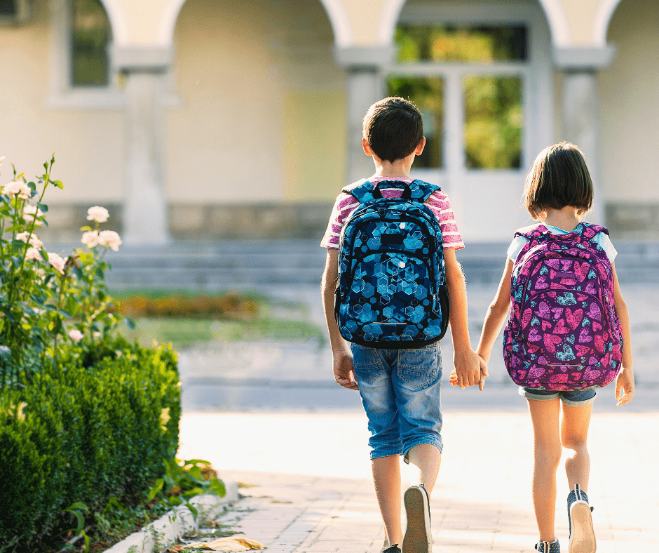 Dos infants van a l'escola el dia d'inici dels curs escolar