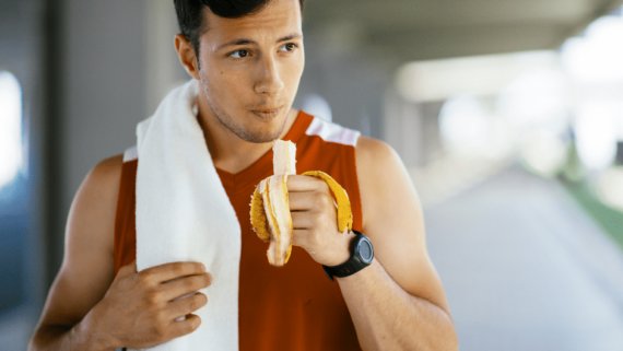 Un esportista menja un plàtan abans de fer exercici. L'alimentació és fonamental per fer esport.