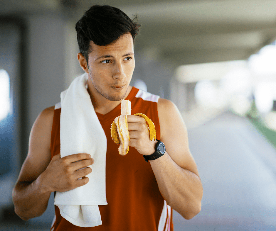 Un esportista menja un plàtan abans de fer exercici. L'alimentació és fonamental per fer esport.
